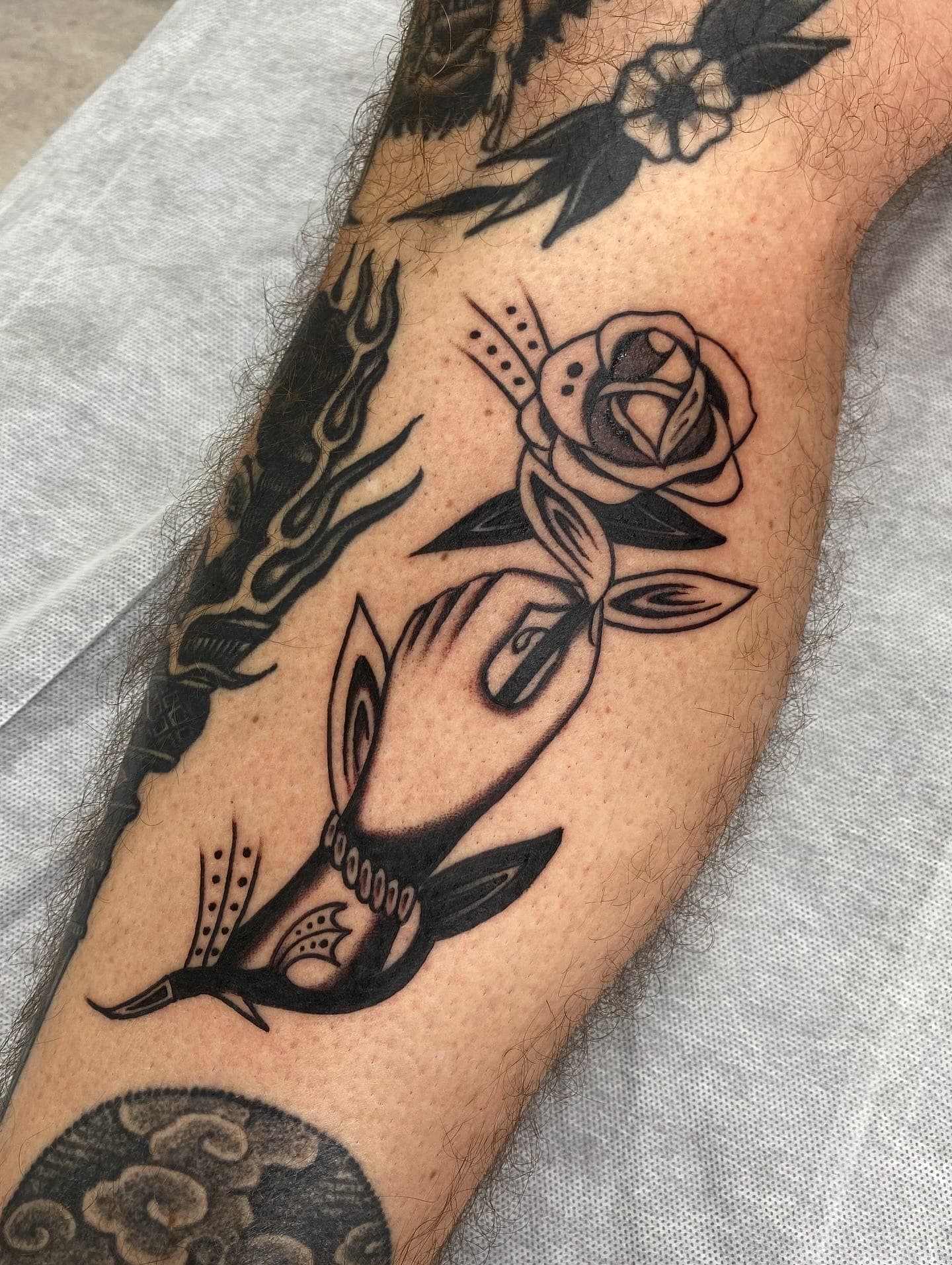 Disembodied holding a rose with a diving swallow below on the outer