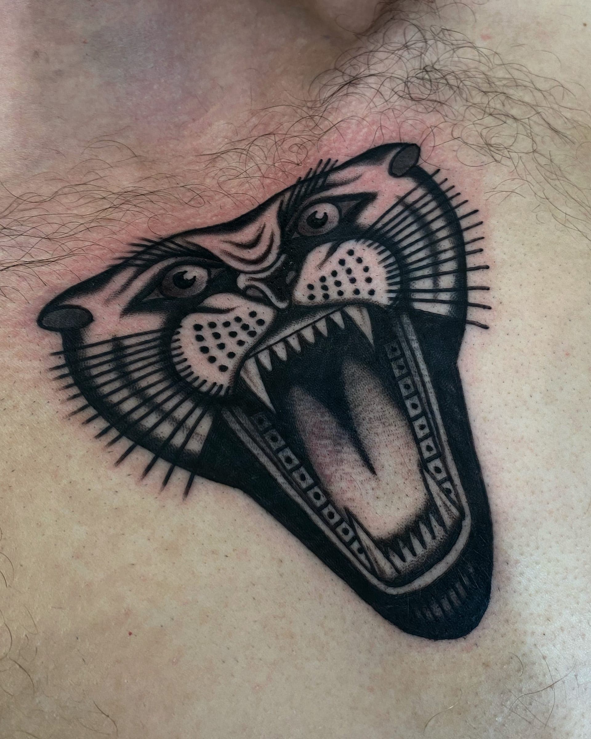 Snarling panther head in solid black ink with bared fangs