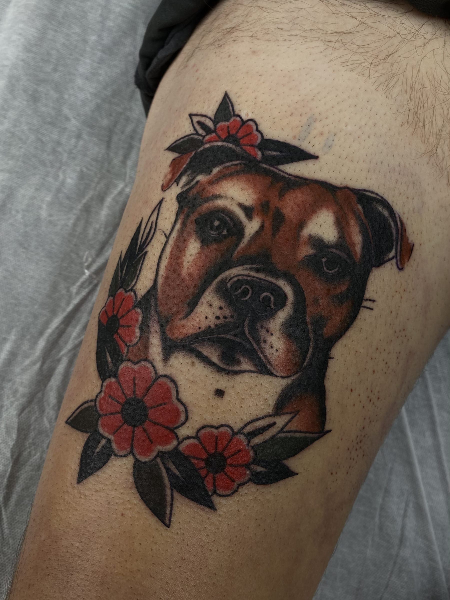 Colour tattoo of a brown and white staffy dog with red flowers